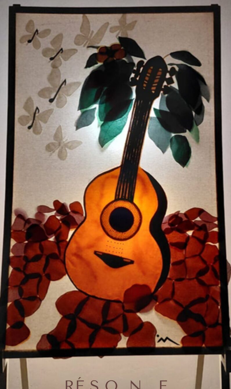 Tapisserie où une guitare devient un avocatier, sur un parterre de pétales pourpres.