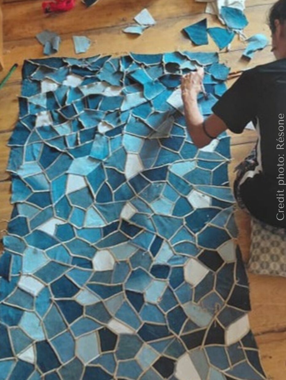 Grande mosaïque murale composée de tessons de jean dans des bleus délavés.